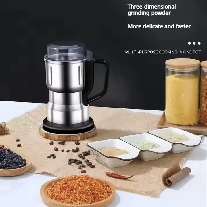 Moulin inox en action avec épices et ingrédients sur table